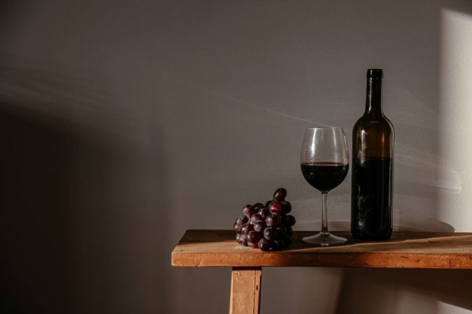 Red wine glass and bottle with fresh grapes showcasing Argentina's wine harvest tradition