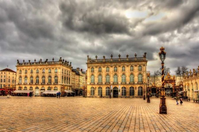 Historic baroque palace square showcasing one of Europe's hidden UNESCO sites under dramatic cloudy sky