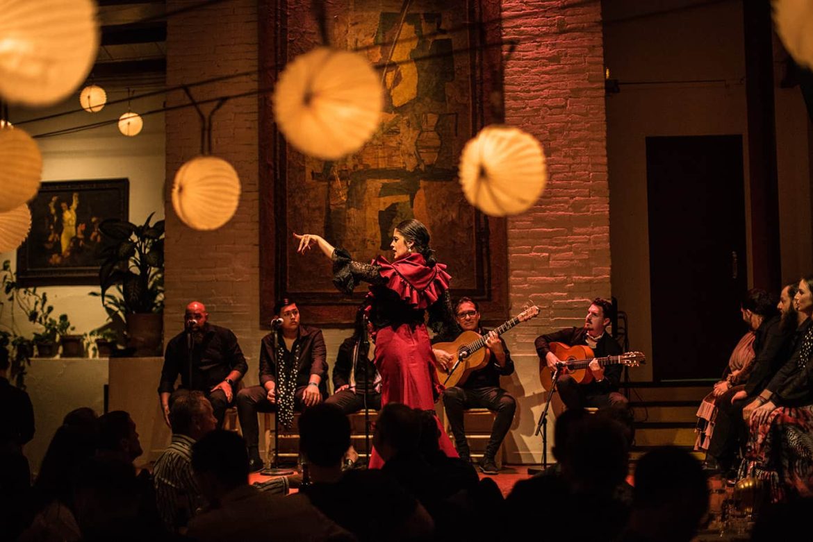 A passionate dancer in a red dress performing at a traditional flamenco show Barcelona.